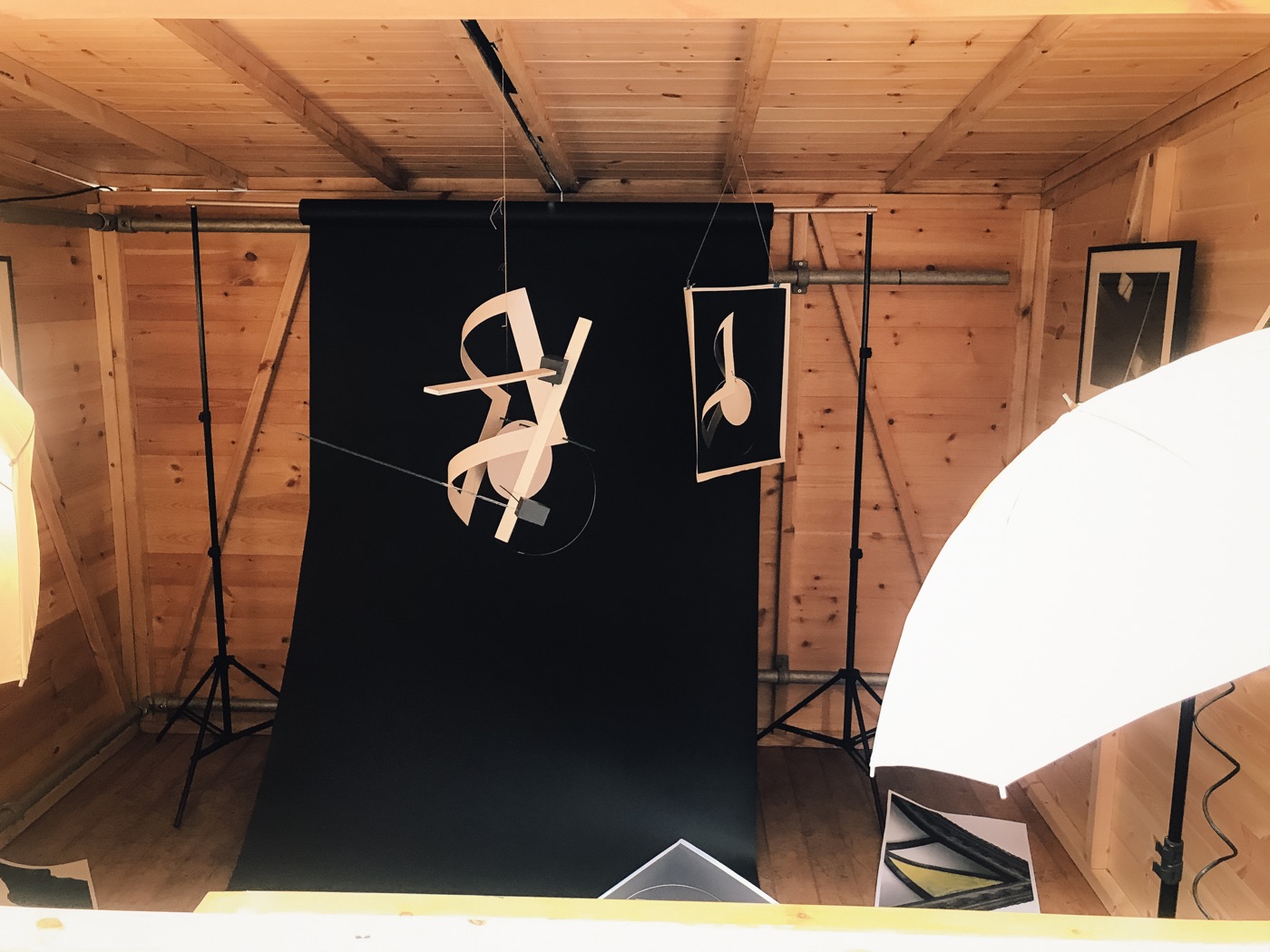 A studio black backdrop with suspended abstract paper forms