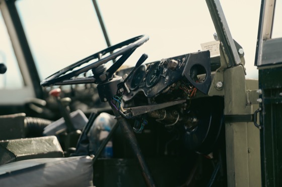 Dashboard and steering wheel detail inside a military-style vehicle.