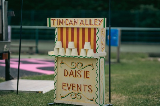 A Tin Can Alley game stall with stacked tins at a 1940s themed event.