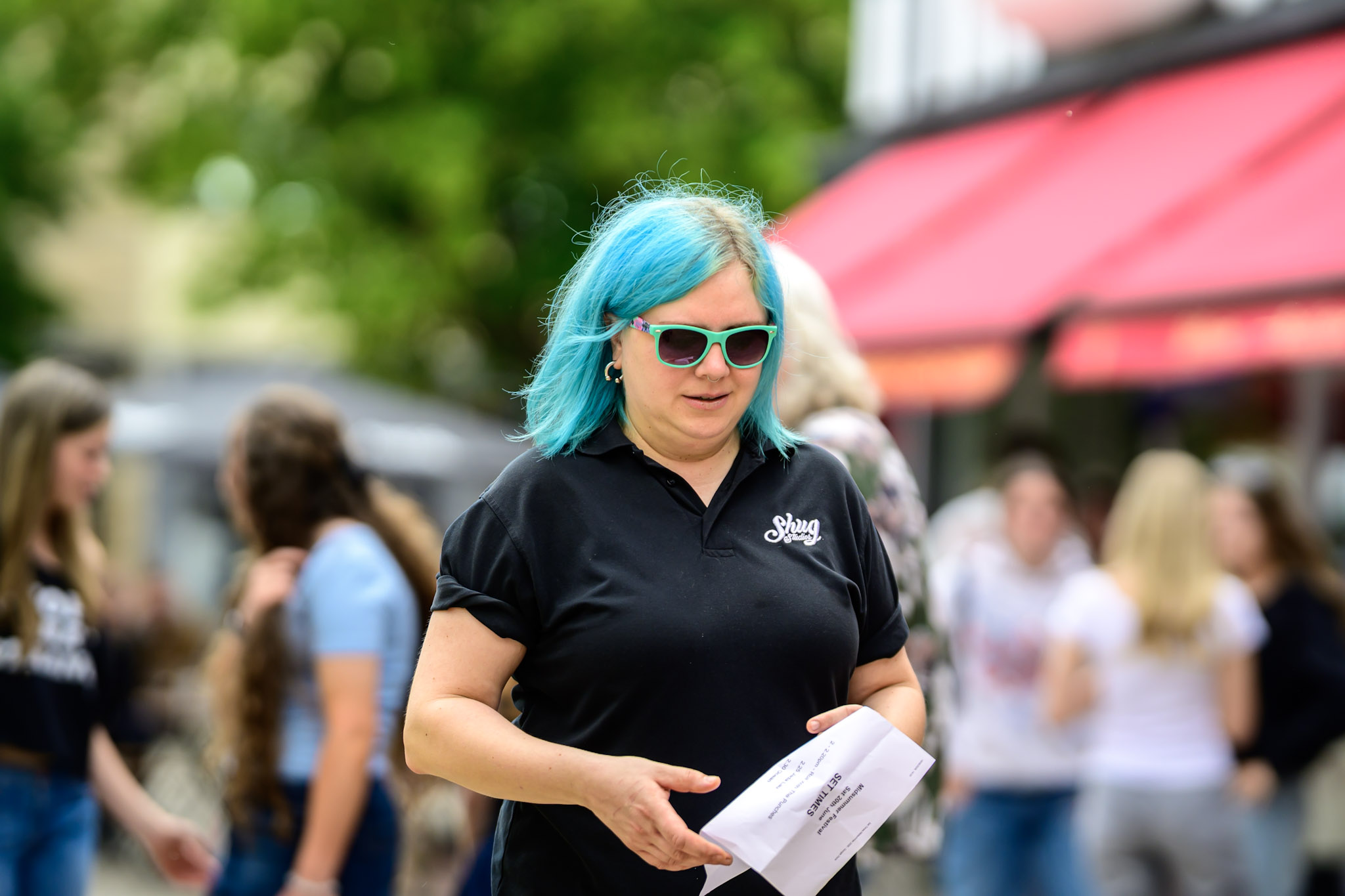 Festival steward or organiser with blue hair holding papers