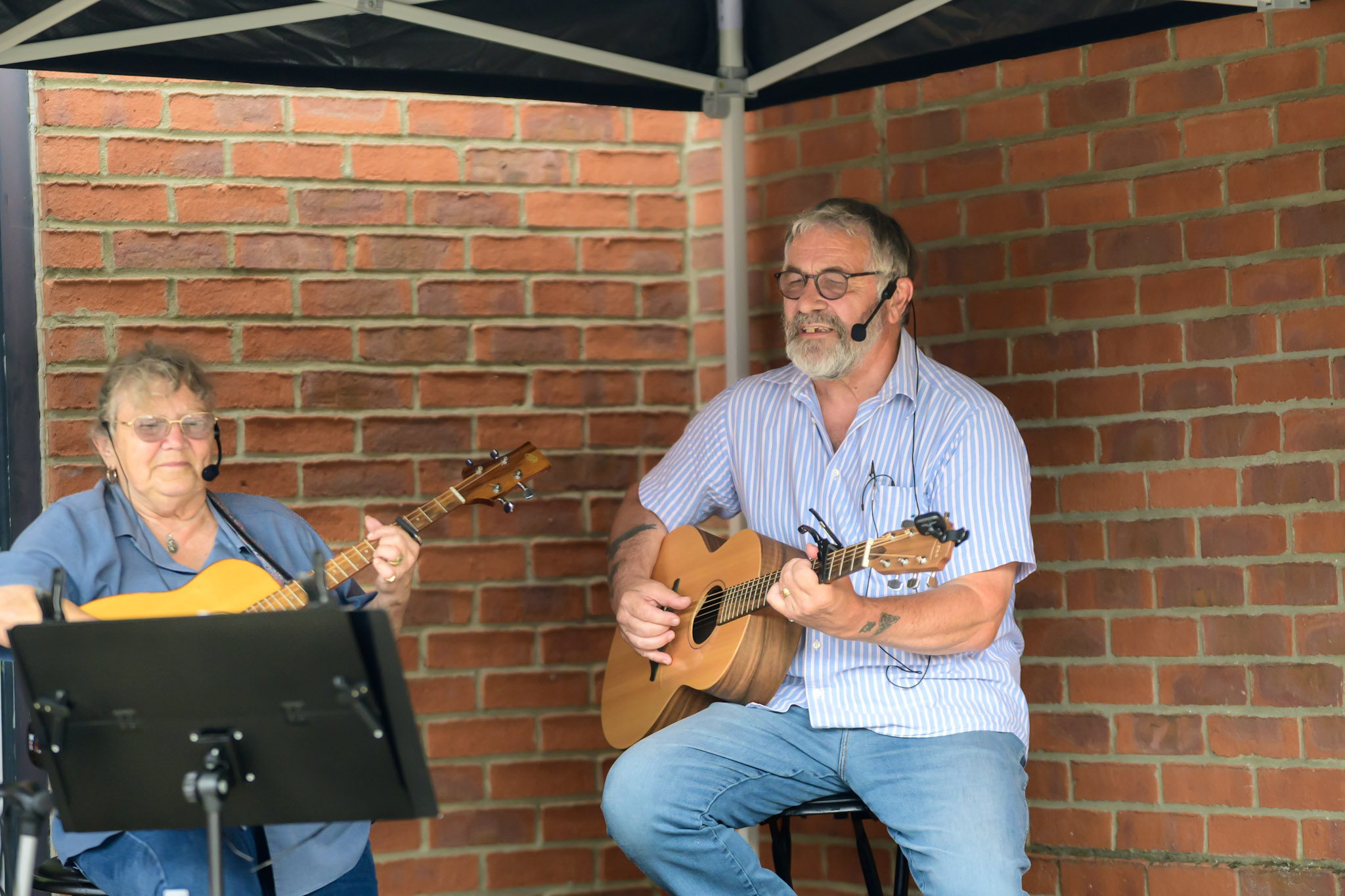 Two musicians performing in a corner of the festival site